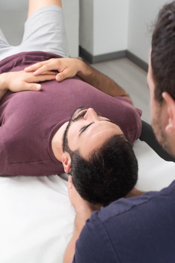 Physiotherapist performing a neck massage on a patient